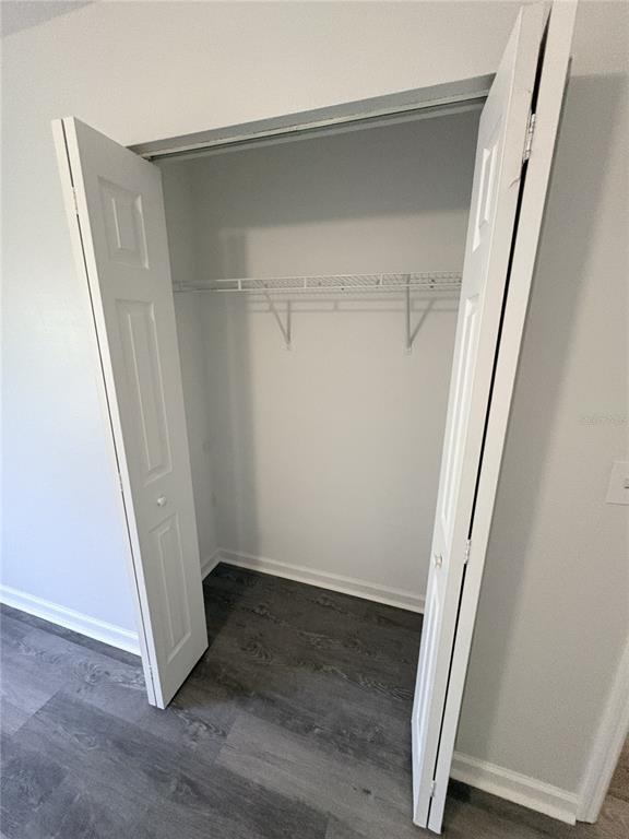 An open closet with a wire shelf and white bifold doors in a room — 2829 NORDMAN AVENUE, NEW SMYRNA BEACH, FL