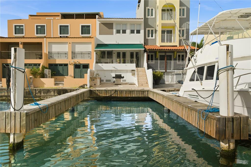 A waterfront view of a multi-story townhouse with a private boat slip and dock — 25 PLAZA MAYOR, HUMACAO, PR