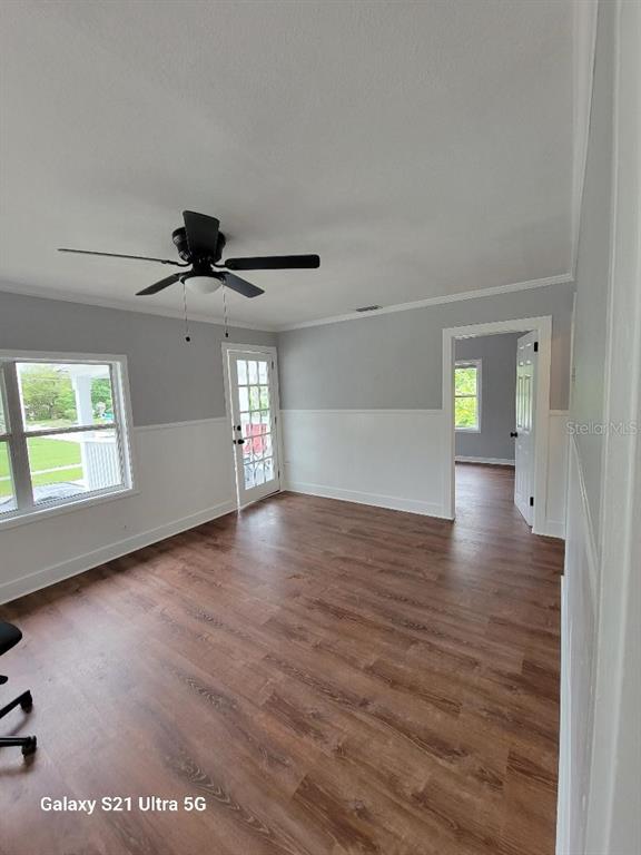 A room with wood-look flooring, white wainscoting, a ceiling fan, and a glass-paneled exterior door — 16 S PRIMROSE DRIVE, ORLANDO, FL