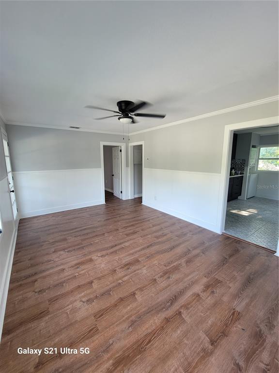 A living room with wood-look flooring, white wainscoting, gray walls, and a ceiling fan — 16 S PRIMROSE DRIVE, ORLANDO, FL
