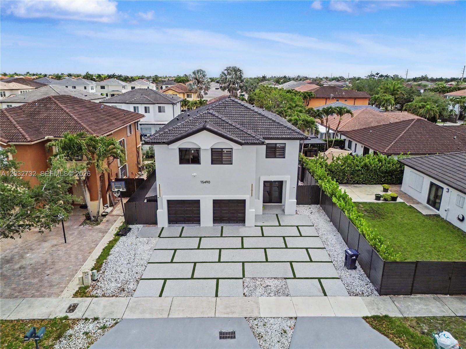 An aerial view shows a two-story house with a paved driveway and a side yard — 15490 SW 18th Ln, Miami FL 33185, MIAMI, FL