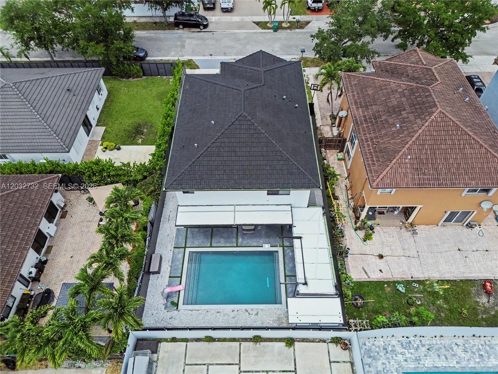 An aerial view shows a house with a dark roof, a swimming pool, and patio — 15490 SW 18th Ln, Miami FL 33185, MIAMI, FL
