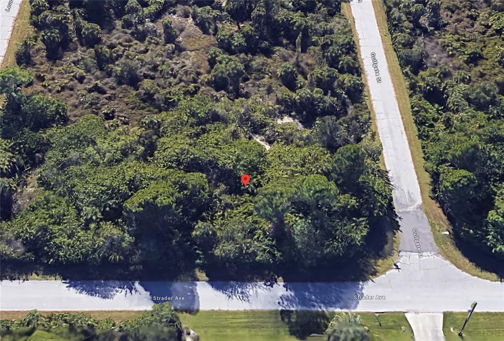 An aerial view shows a wooded, undeveloped corner lot at the intersection of two streets — 14143 STRADER AVENUE, PORT CHARLOTTE, FL