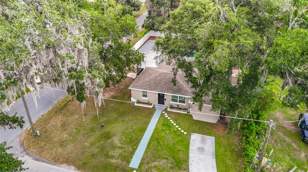 An aerial view shows a single-story house with a brown roof, front walkway, and trees — 14402 13TH STREET, DADE CITY, FL