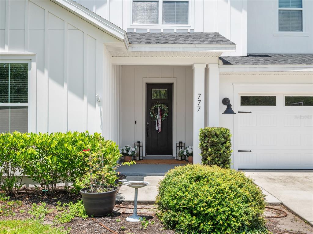 The exterior of a white house features a dark front door and a garage — 777 HALIFAX AVENUE, WINTER PARK, FL
