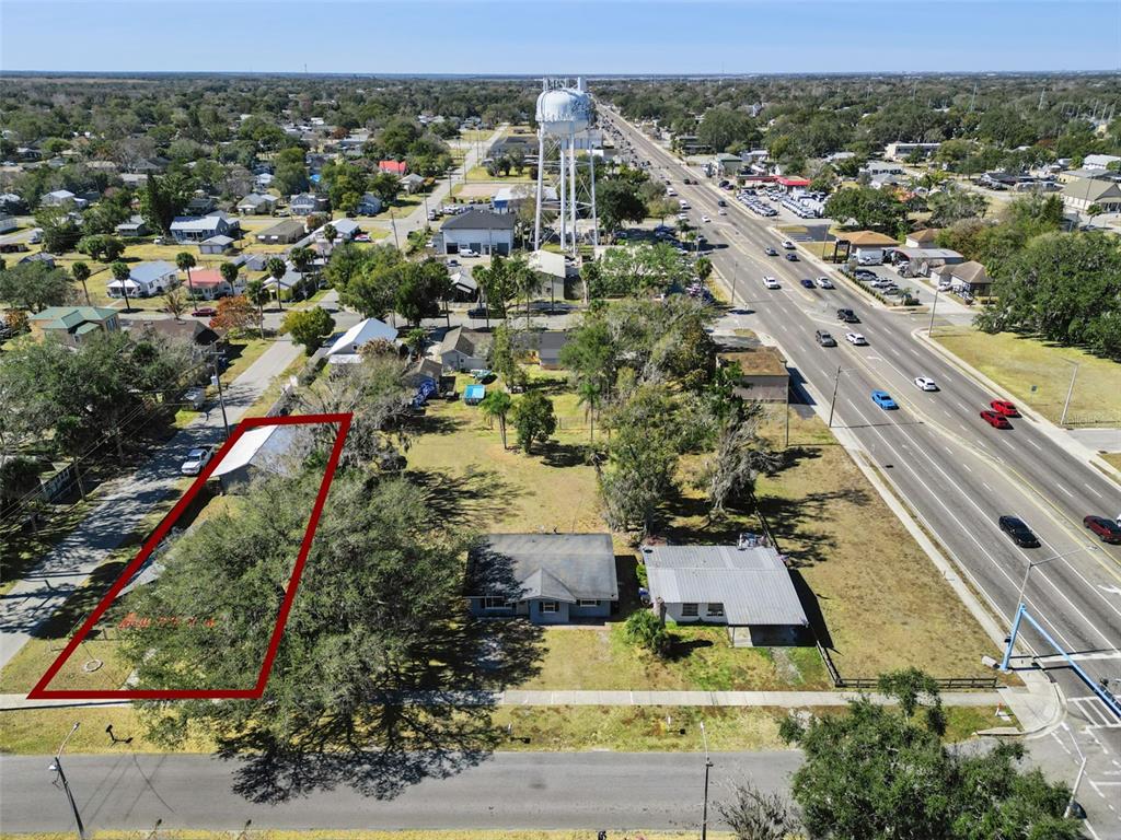 An aerial view shows a residential lot outlined in red next to two small houses — 1322 NEW YORK AVENUE, ST CLOUD, FL