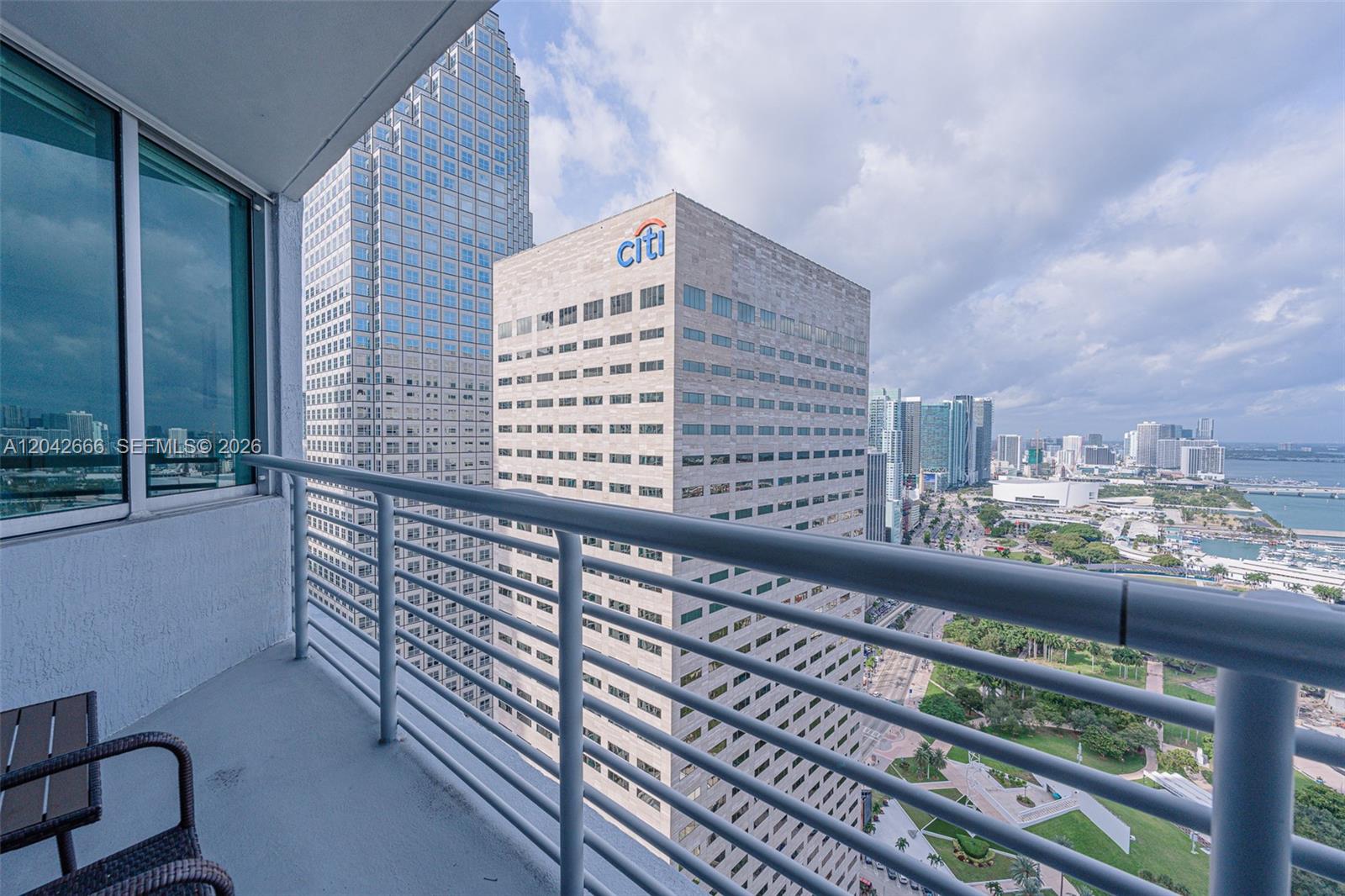 A balcony overlooks a city skyline featuring a prominent Citi building and a nearby park — 325 S BISCAYNE BLVD # 4222, Miami FL 33131, MIAMI, FL