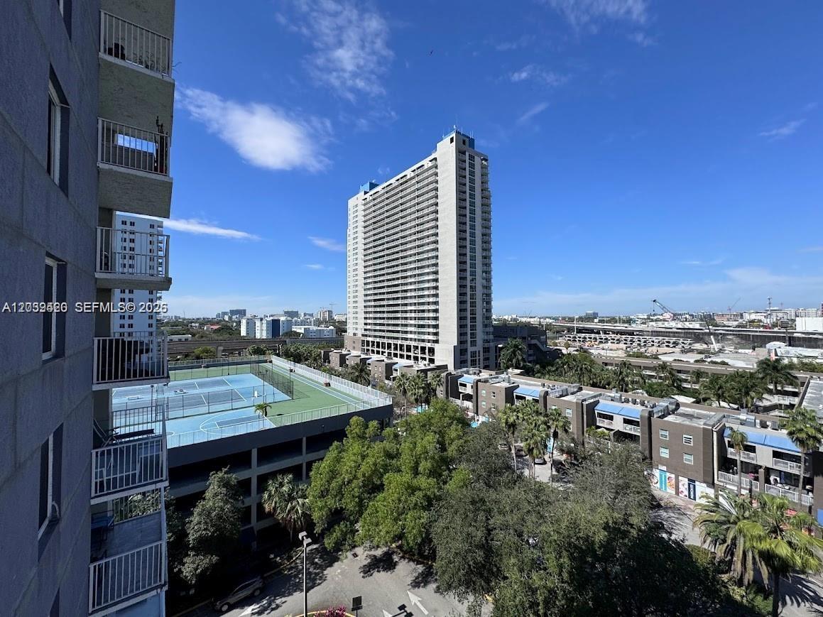 An elevated view shows a tall apartment building, a tennis court, and surrounding urban landscape — 800 N Miami Ave # 1008, Miami FL 33136, MIAMI, FL