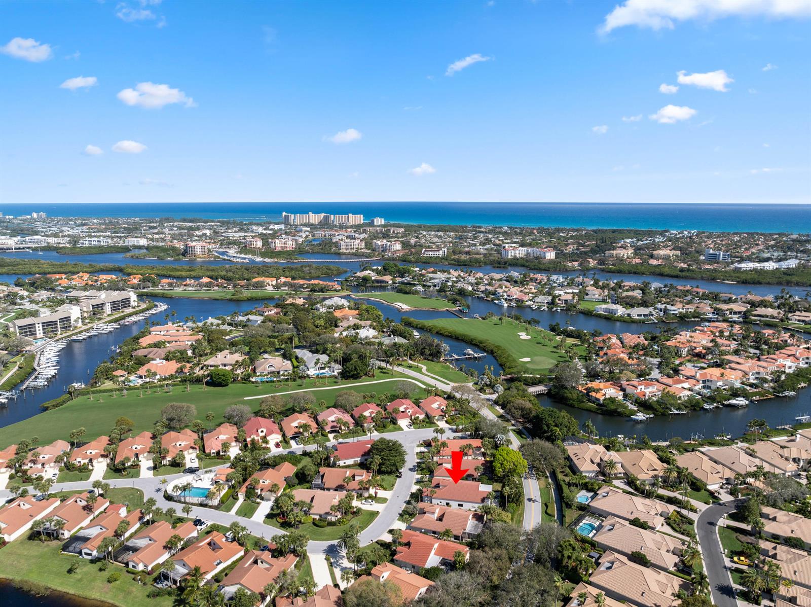 An aerial view shows a residential neighborhood with red-roofed houses near a golf course — 16613 Hidden Cove Drive, Jupiter FL 33477, JUPITER, FL