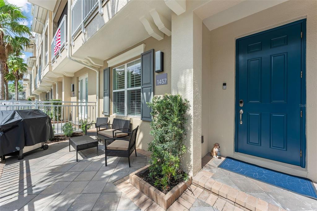A patio area features a blue front door, outdoor seating, and a small potted plant — 1457 LAKE GEORGE DRIVE UNIT 1457, LAKE MARY, FL