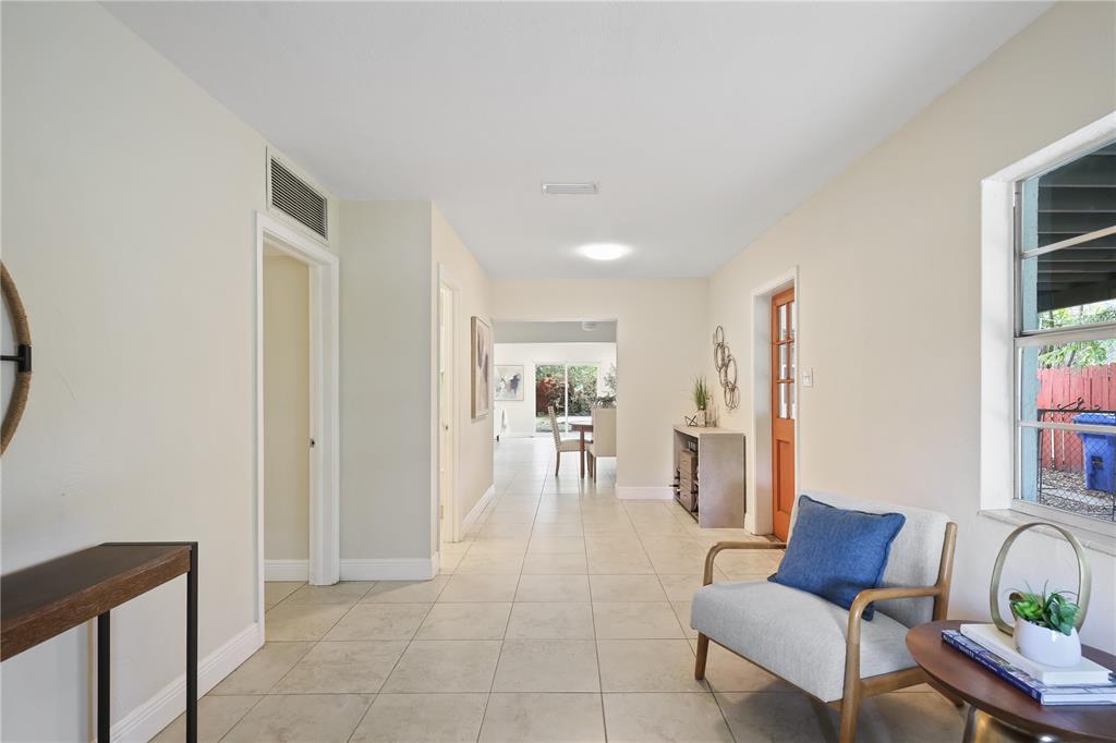 A bright hallway with tile flooring leads to a dining area with a sliding glass door — 6311 37TH AVENUE N, ST PETERSBURG, FL