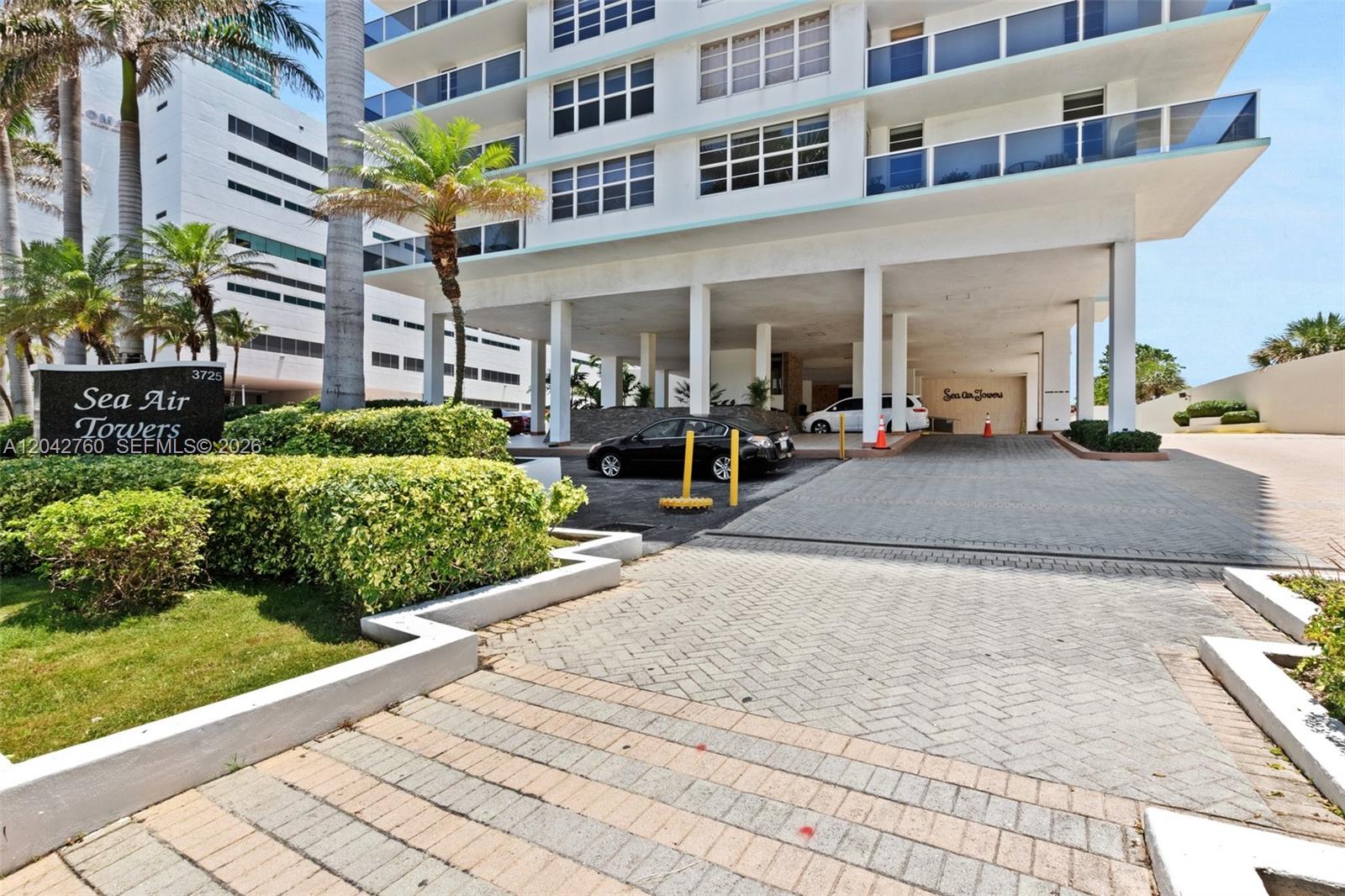 The exterior of a multi-story apartment building features a covered driveway and a landscaped entrance — 3725 S Ocean Dr # 921, Hollywood FL 33019, HOLLYWOOD, FL