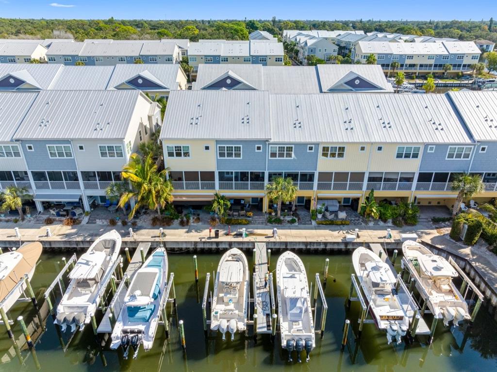 An aerial view of waterfront townhomes with private boat slips and docked motorboats — 6057 MOORINGS DRIVE S, ST PETERSBURG, FL