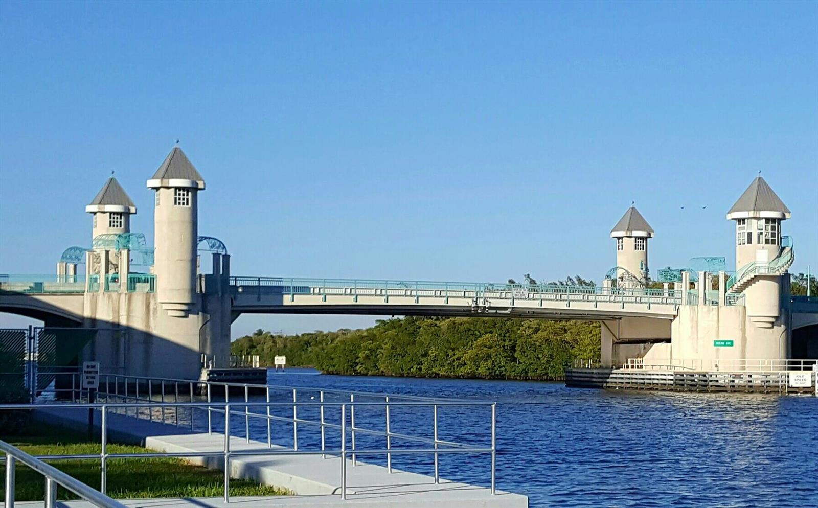 A drawbridge with four decorative towers spans a river surrounded by lush green trees — 350 Horizons E # 206, Boynton Beach FL 33435, BOYNTON BEACH, FL