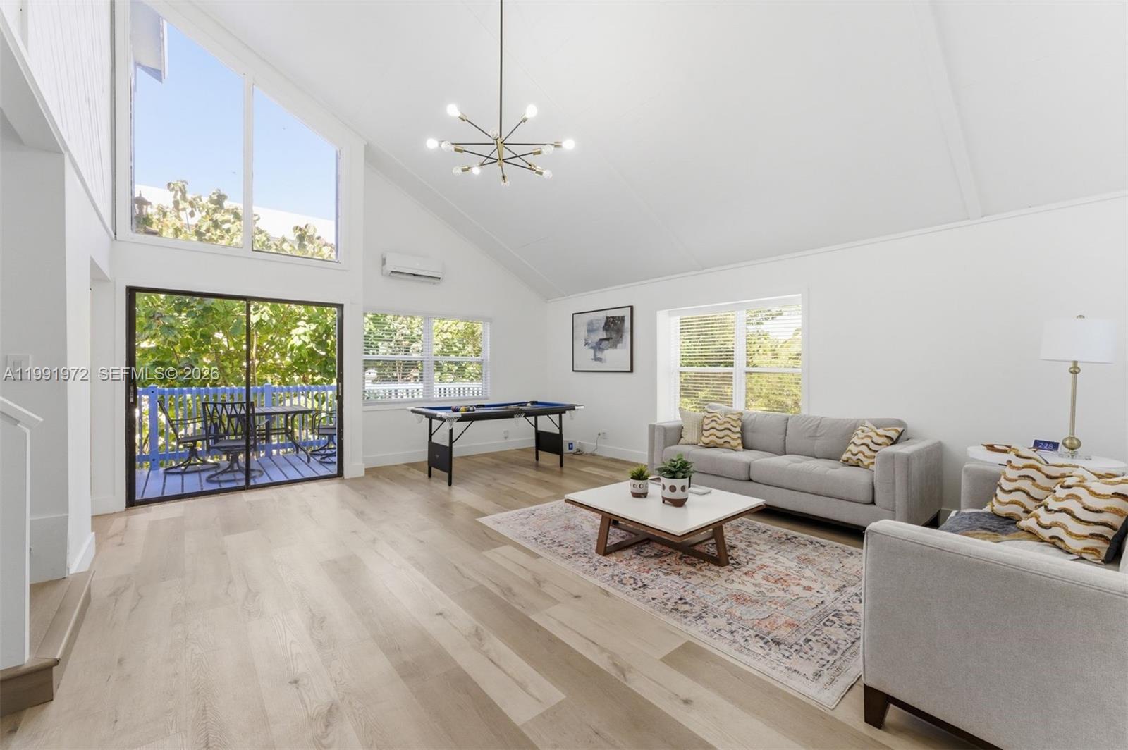 A bright living room features vaulted ceilings, light wood floors, and a pool table — 154 Sebring Dr, Tavernier FL 33070, TAVERNIER, FL