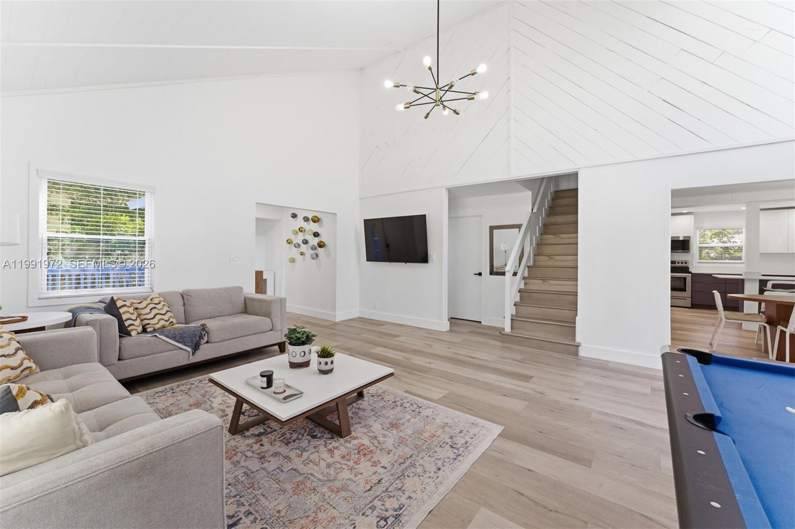 A living room features light wood floors, a vaulted ceiling, a staircase, and a pool table — 154 Sebring Dr, Tavernier FL 33070, TAVERNIER, FL