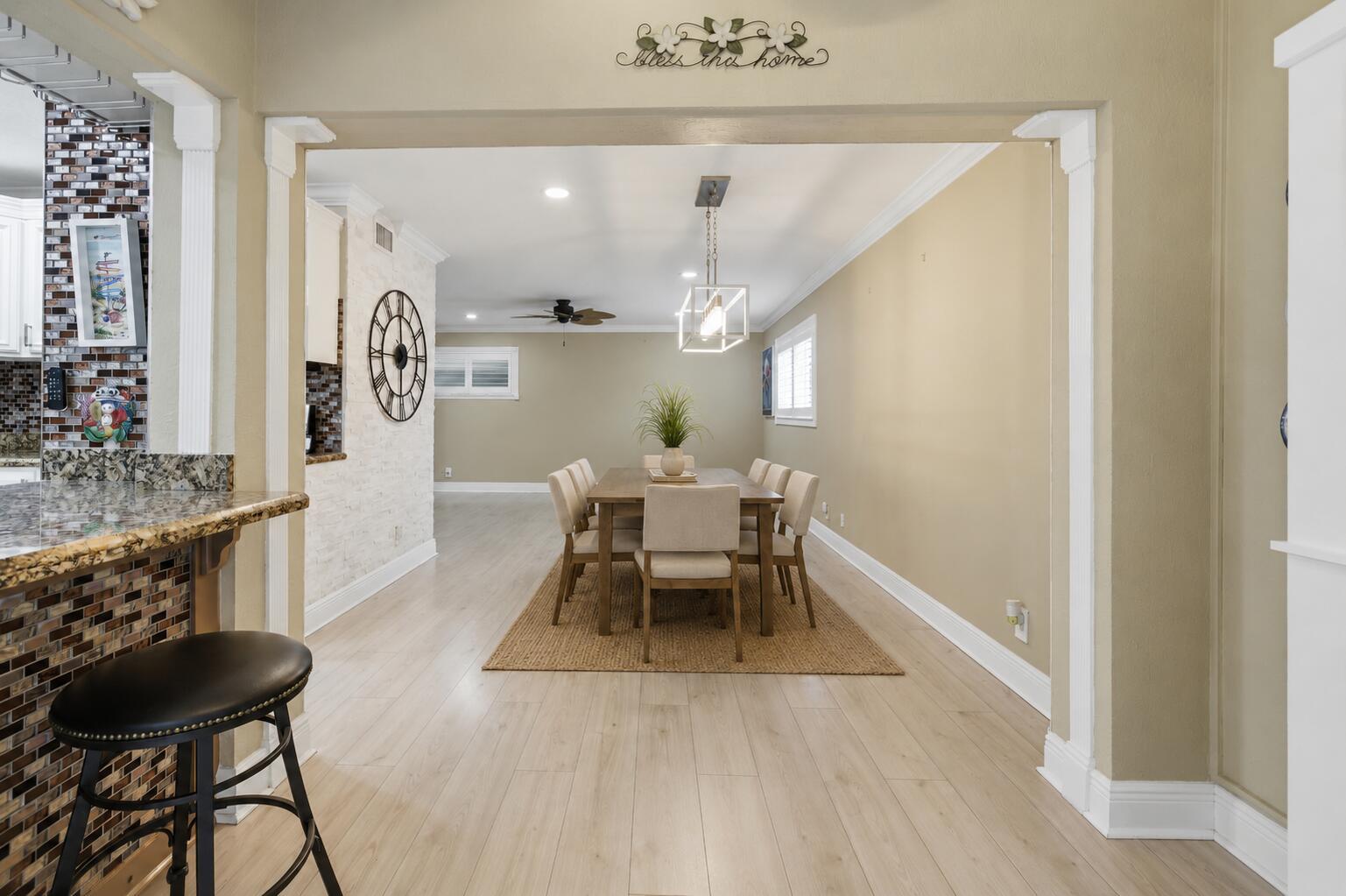A dining room with a wooden table and chairs sits adjacent to a kitchen counter — 34 Colonial Club Drive # 101, Boynton Beach FL 33435, BOYNTON BEACH, FL