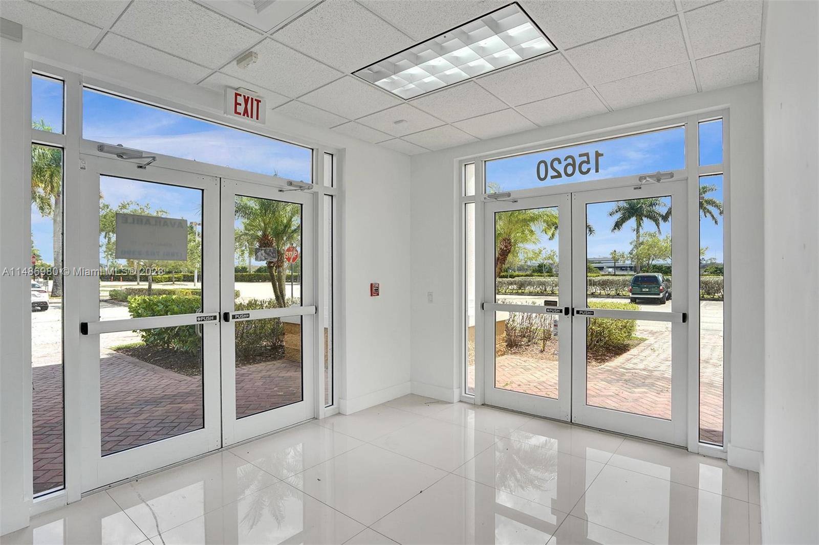 An interior view of a bright commercial lobby with glass double doors and tiled floors — 15620 SW 29th St, Miramar FL 33027, MIRAMAR, FL