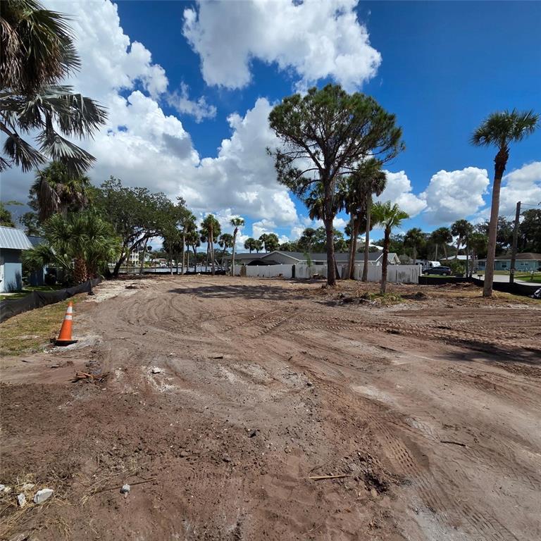 A cleared, sandy residential lot features several palm trees and a white privacy fence — 5345 TARRY LANE, NEW PORT RICHEY, FL