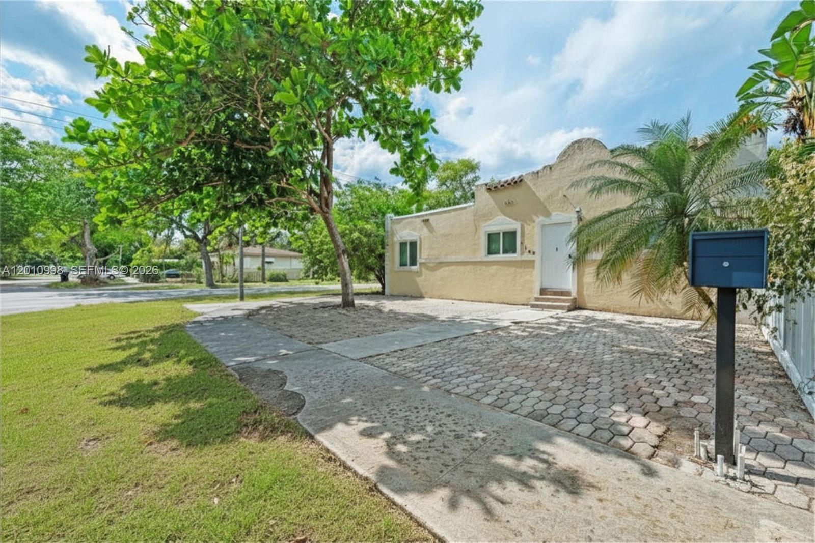 A single-story stucco house with a paved driveway and a large tree in the yard — 1199 NW 121st St, North Miami FL 33168, NORTH MIAMI, FL