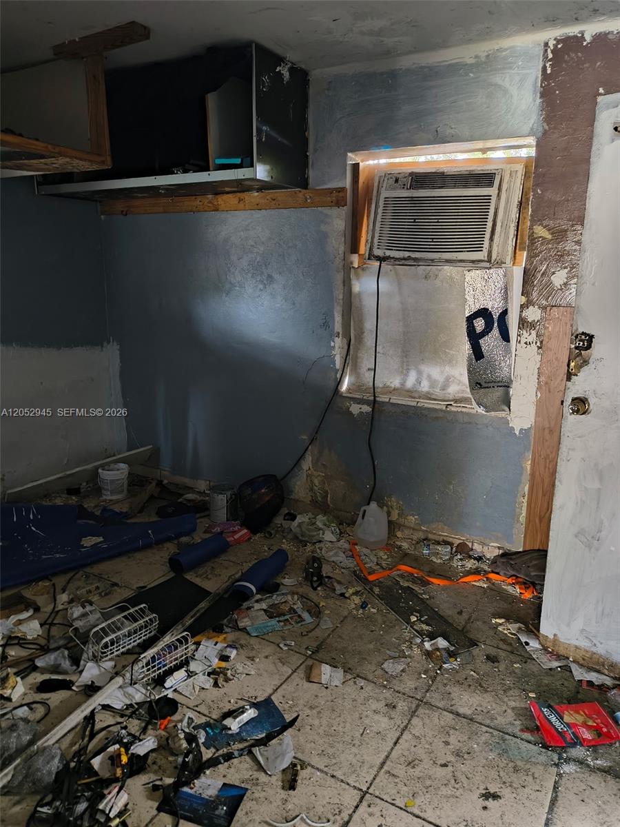 A cluttered, unfinished room features a window air conditioning unit and exposed wall surfaces — 5718 Mckinley St, Hollywood FL 33021, HOLLYWOOD, FL