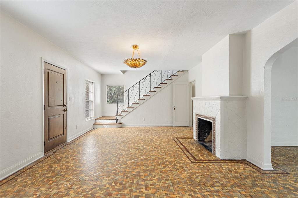 A living room features a fireplace, a staircase with iron railings, and patterned tile flooring — 437 RICHMOND STREET, ORLANDO, FL