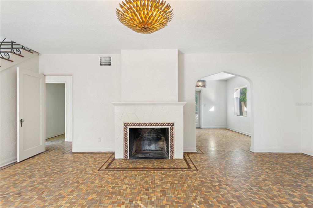 A living room features a fireplace with white tile, a gold light fixture, and mosaic flooring — 437 RICHMOND STREET, ORLANDO, FL