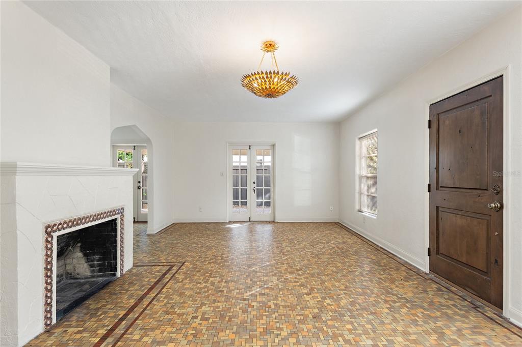 A living room with a fireplace, mosaic tile flooring, a chandelier, and a wooden door — 437 RICHMOND STREET, ORLANDO, FL