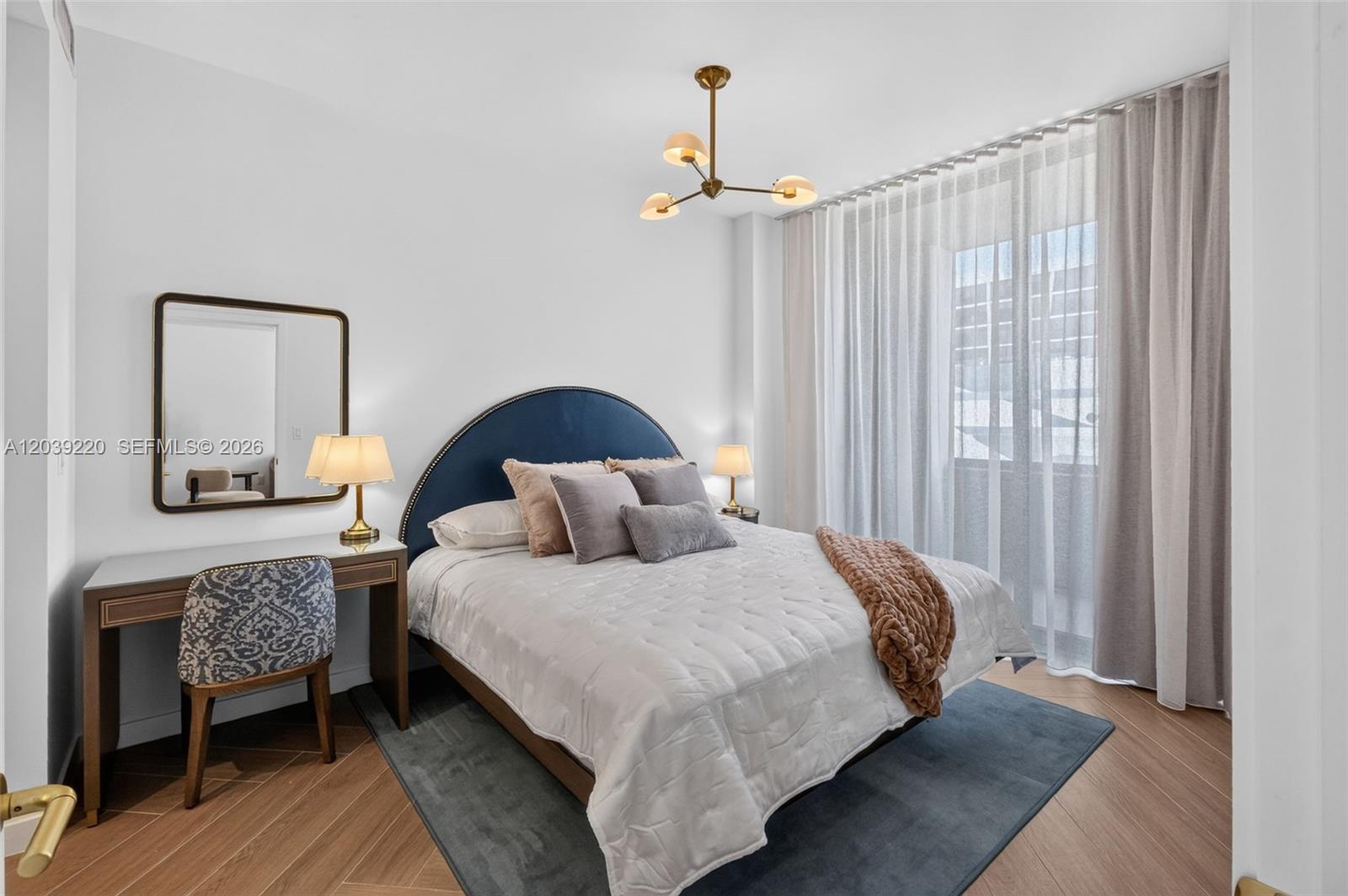 A bedroom features a blue arched headboard, a vanity desk, and a modern light fixture — 2700 NW 2ND AVE # 528, Miami FL 33127, MIAMI, FL