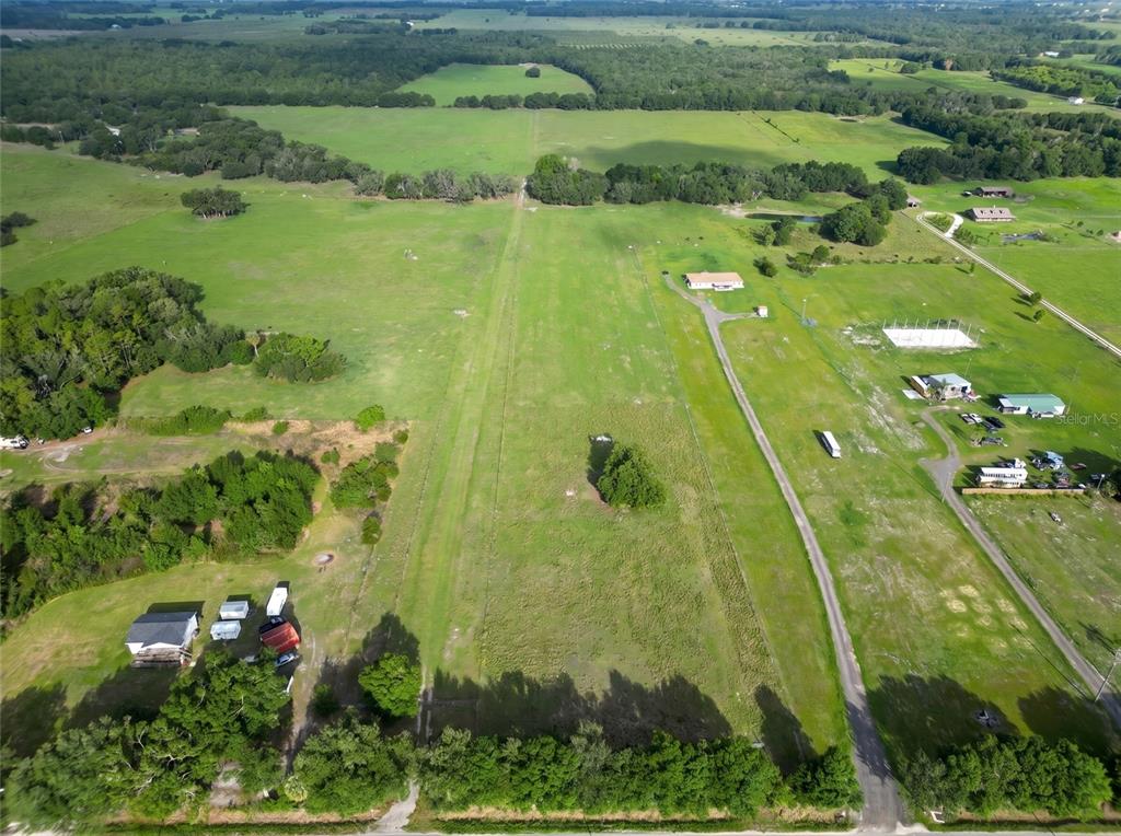An aerial view shows a large, grassy rural property with several buildings and tree lines — N ED WELLS ROAD, WAUCHULA, FL