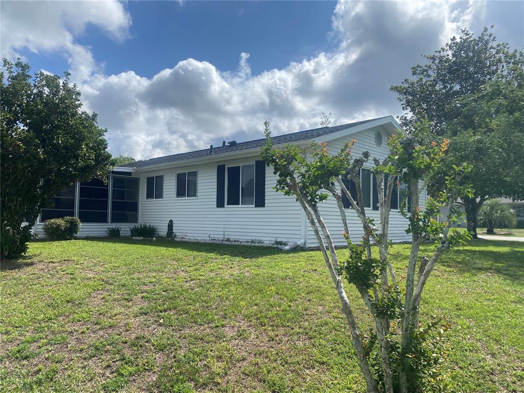 A white single-story house with a screened-in porch sits on a grassy lawn — 10986 SW 86TH TERRACE, OCALA, FL