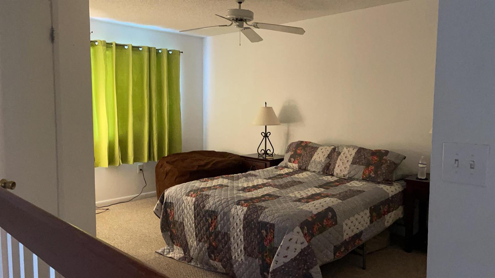 A bedroom features a bed with a patterned quilt, a ceiling fan, and lime green curtains — 17485 NW 67th Court # 21, Hialeah FL 33015, HIALEAH, FL