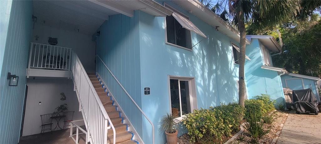 A two-story light blue building features an exterior staircase leading to an upper-level balcony — 3775 40TH LANE S UNIT L, ST PETERSBURG, FL