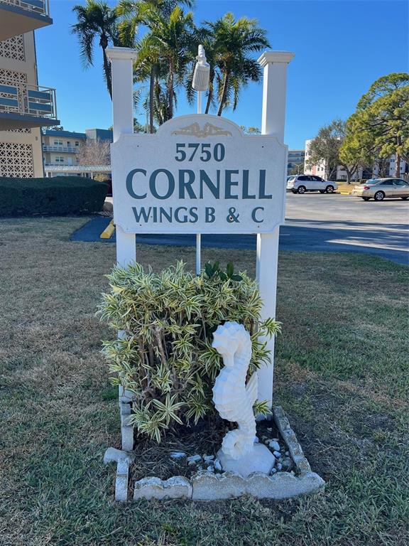 A white sign for Cornell Wings B & C stands in a grassy area — 5750 80TH STREET N UNIT B203, ST PETERSBURG, FL