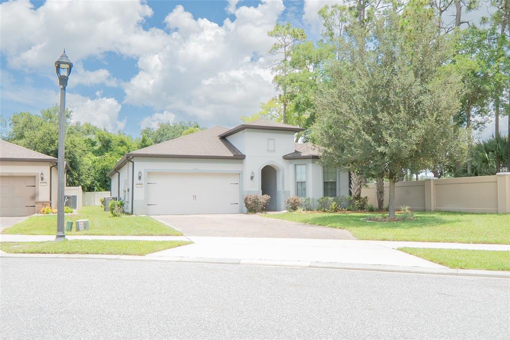 A single-story suburban house with a two-car garage, light-colored stucco exterior, and a paved driveway — 1188 PATTERSON TERRACE, LAKE MARY, FL