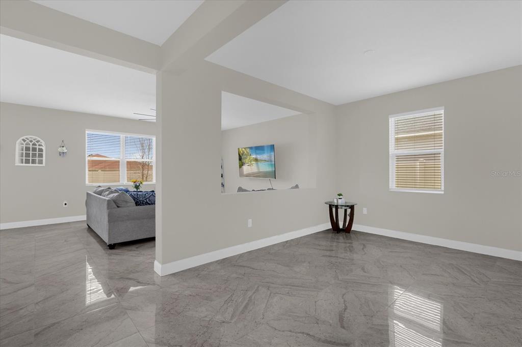 A living room with gray sofas, a wooden coffee table, and an open-concept kitchen — 4566 ORCHARD GROVE ROAD, ST CLOUD, FL