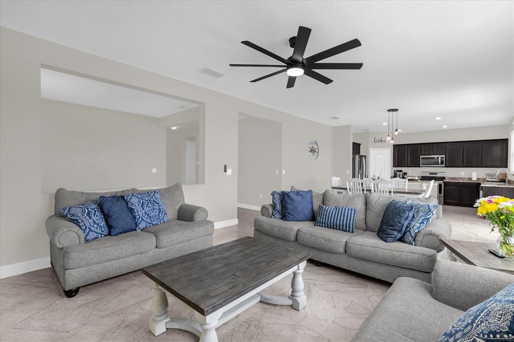 A dining area with a wooden table and chairs sits adjacent to an open kitchen — 4566 ORCHARD GROVE ROAD, ST CLOUD, FL