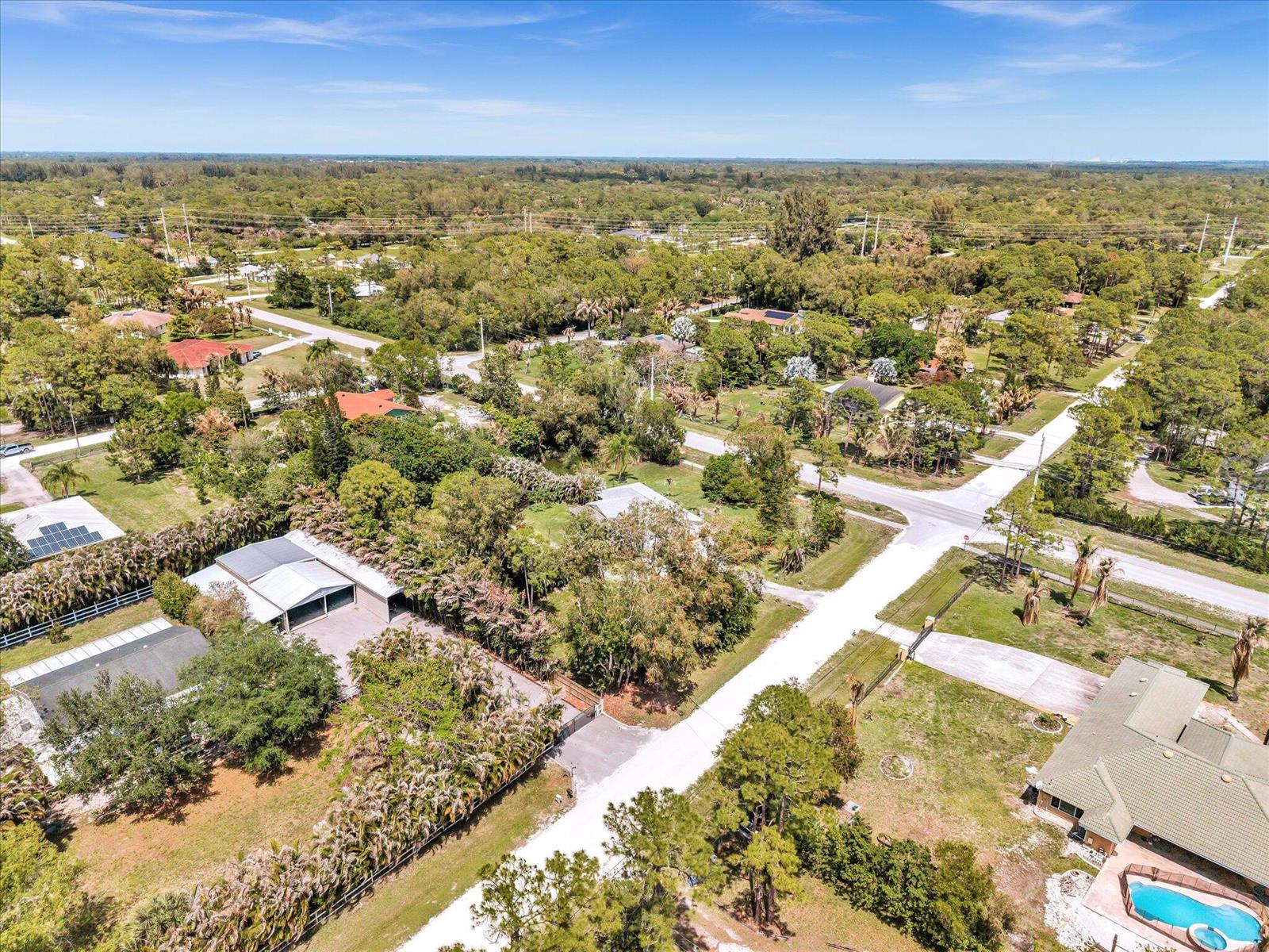 An aerial view of a residential neighborhood with houses, trees, and paved roads — 5209 Coconut Boulevard, FL 33411, FL