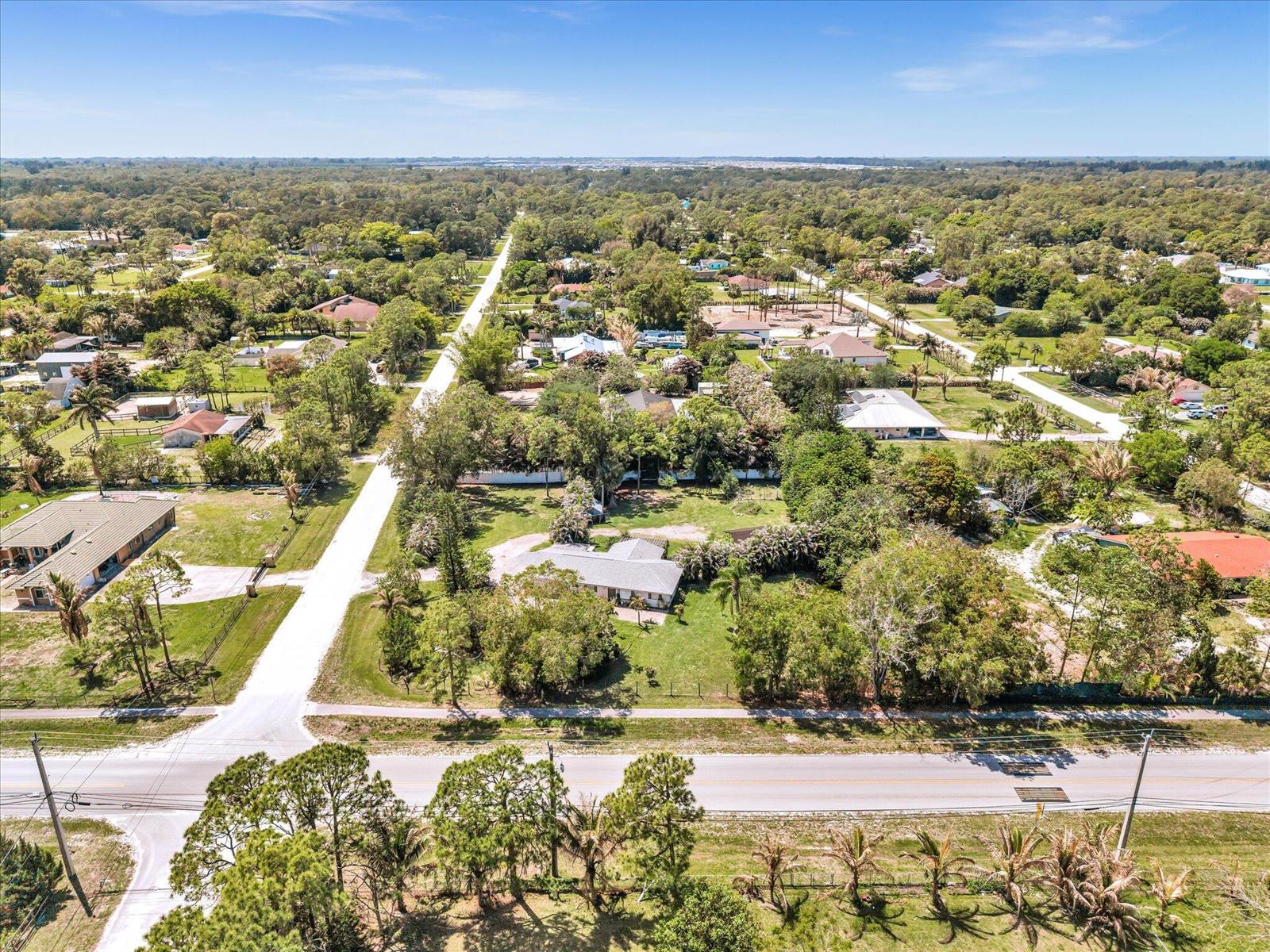 An aerial view shows a residential neighborhood with houses, trees, and a paved road — 5209 Coconut Boulevard, FL 33411, FL