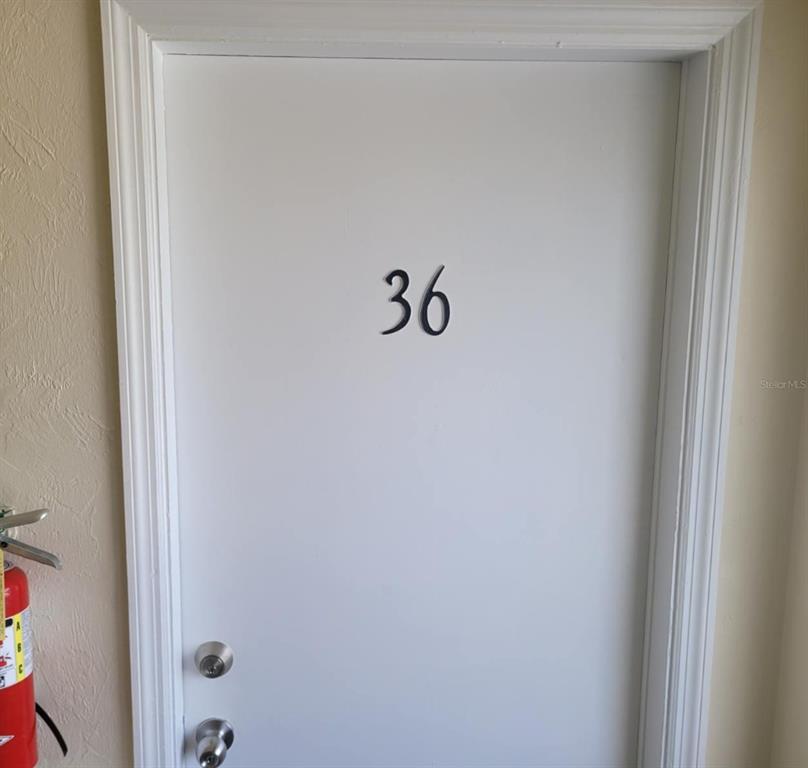 A white door marked with the number 36 features two silver doorknobs — 22481 WESTCHESTER BOULEVARD UNIT B36, PORT CHARLOTTE, FL