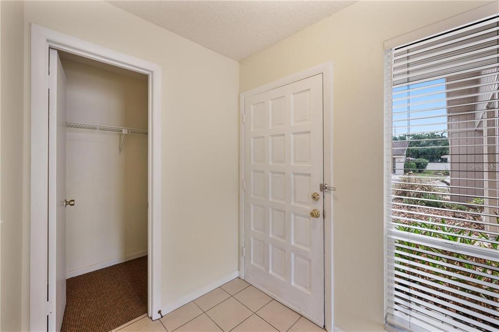 An entryway features a tiled floor, a white front door, and an open storage closet — 4231 OAK LOOP UNIT 51, MULBERRY, FL