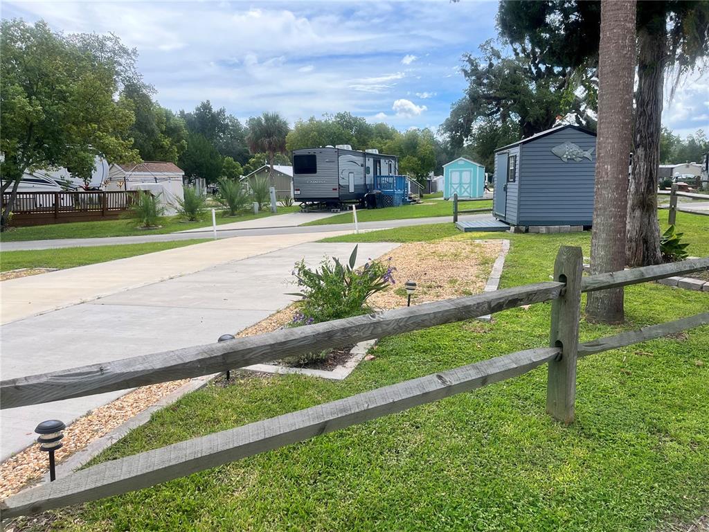 A concrete driveway leads to a travel trailer parked in a grassy residential lot — 2888 NE 102ND TERRACE, SILVER SPRINGS, FL