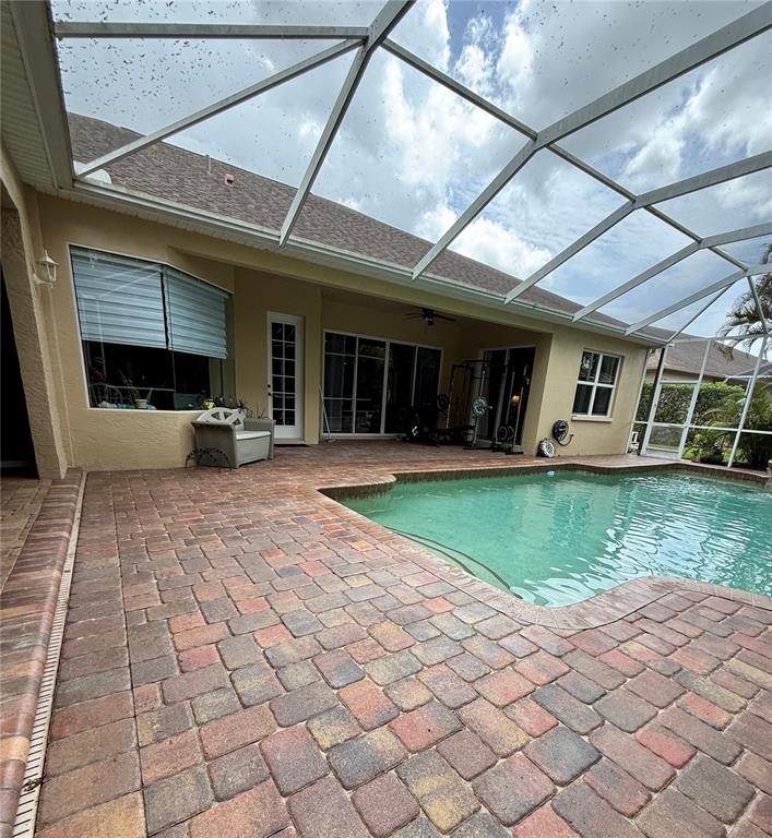 A screened-in patio features a brick paver deck and a swimming pool — 11805 SOFT RUSH TERRACE, BRADENTON, FL