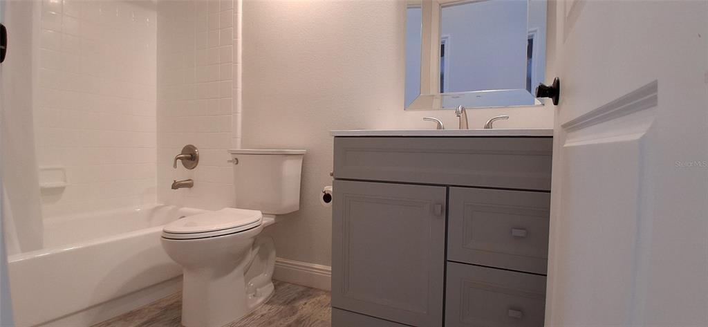 A bathroom features a gray vanity, a white toilet, and a tiled shower-tub combination — 1432 AVLEIGH CIRCLE, ORLANDO, FL