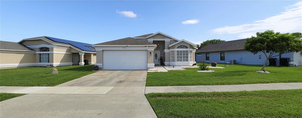 A single-story suburban house with a two-car garage and a light-colored stucco exterior — 1432 AVLEIGH CIRCLE, ORLANDO, FL