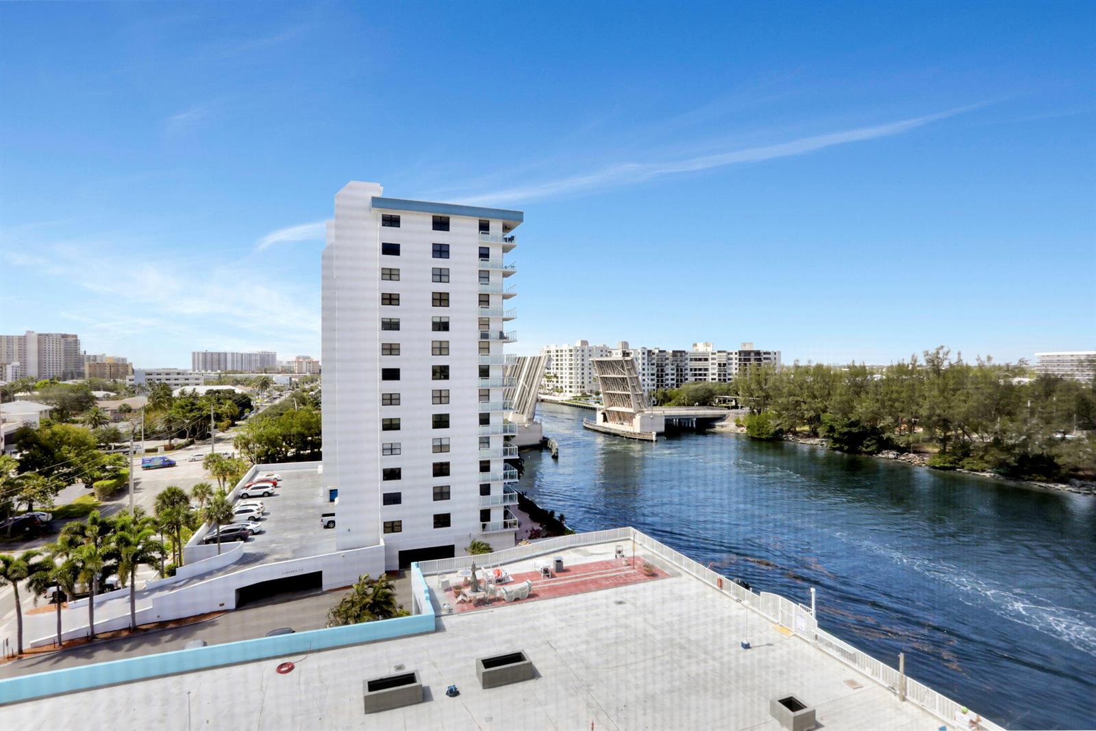 An elevated view shows a tall white apartment building, a parking garage, and a drawbridge — 1505 N Riverside Drive # 802, Pompano Beach FL 33062, POMPANO BEACH, FL