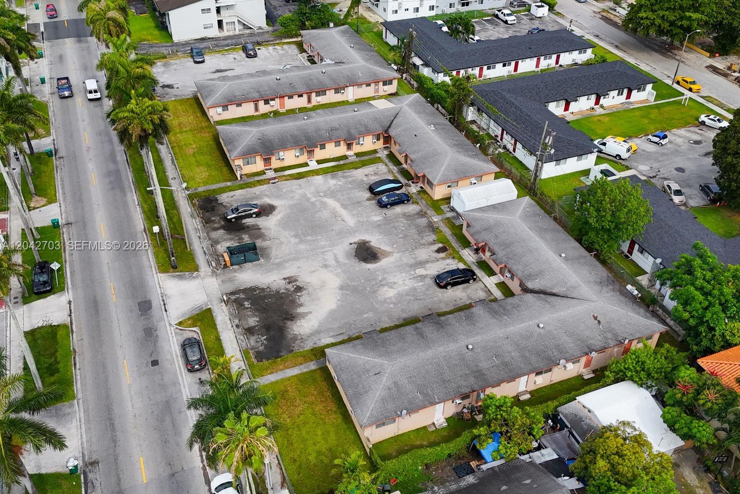 An aerial view shows two L-shaped apartment buildings with a central parking lot — 1915 NW 28th St, Miami FL 33142, MIAMI, FL