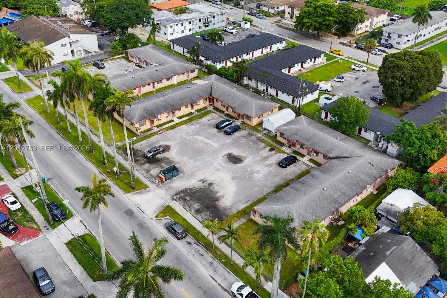 An aerial view shows several single-story apartment buildings surrounding a central parking lot — 1915 NW 28th St, Miami FL 33142, MIAMI, FL