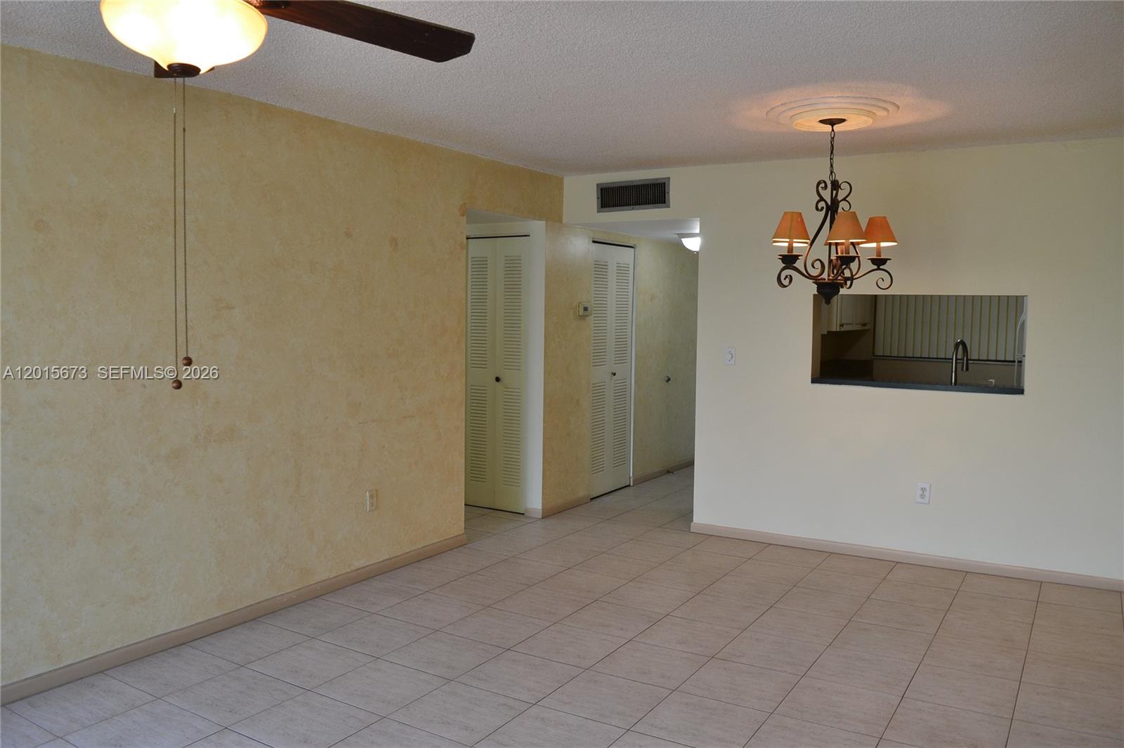 An interior view shows a tiled living area with a ceiling fan and chandelier — 10855 SW 112th Ave # 309, Miami FL 33176, MIAMI, FL
