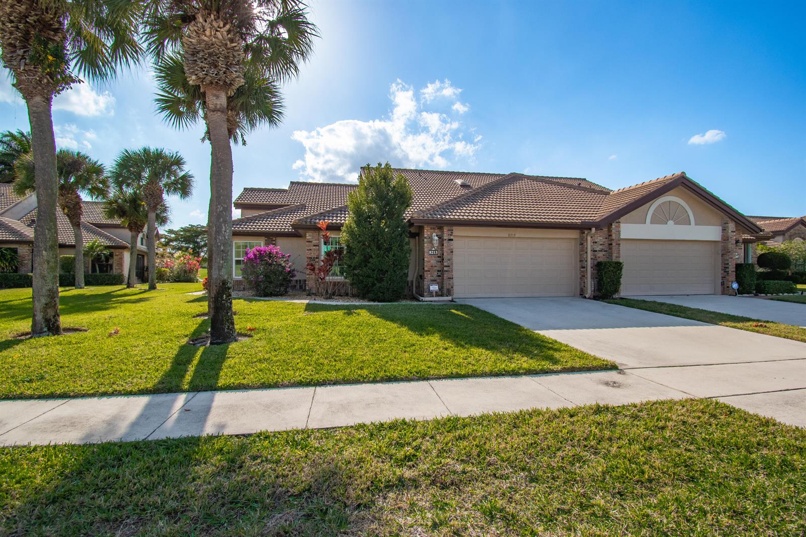 A single-story house with a tile roof, two garage doors, and palm trees in front — 8213 Cassia Drive, Boynton Beach FL 33472, BOYNTON BEACH, FL